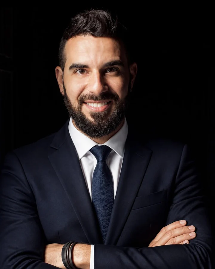 Jairo Rodarte, de terno azul-marinho e braços cruzados, sorrindo